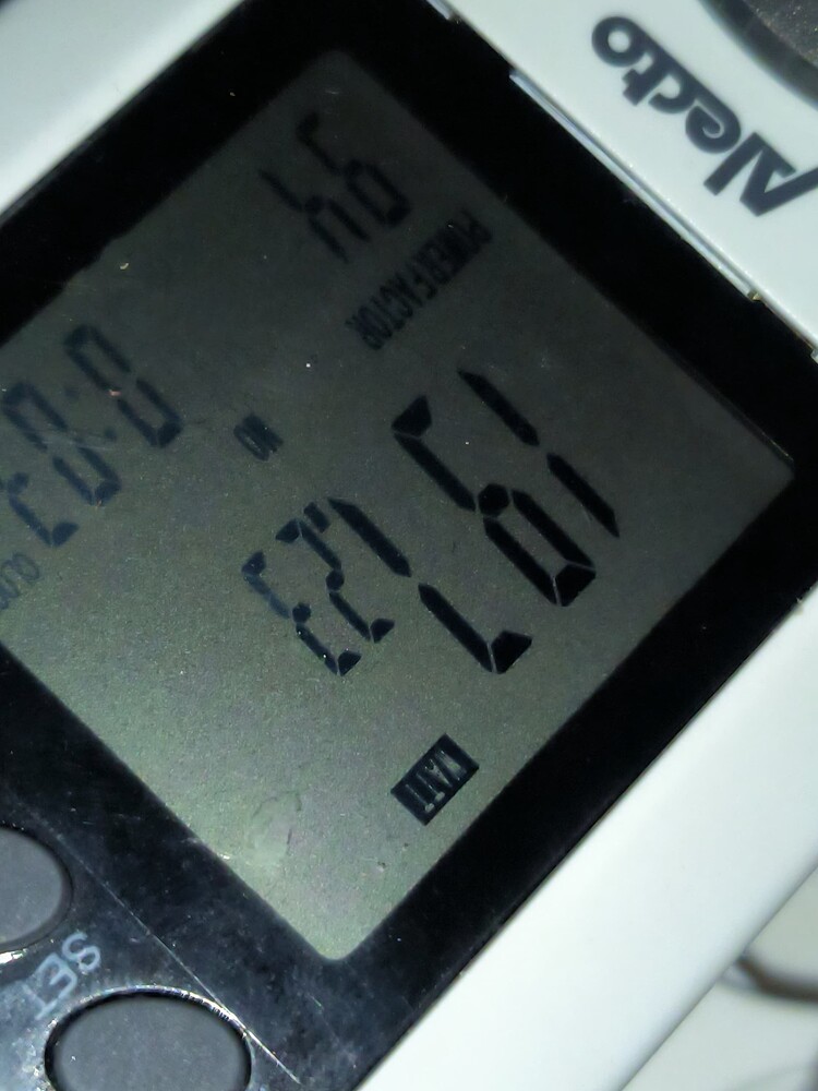 Ein digitales Messgerät zeigt die Wattzahl 197.23 an, daneben 0.94 für den Powerfaktor und 00:03 für die Zeit.