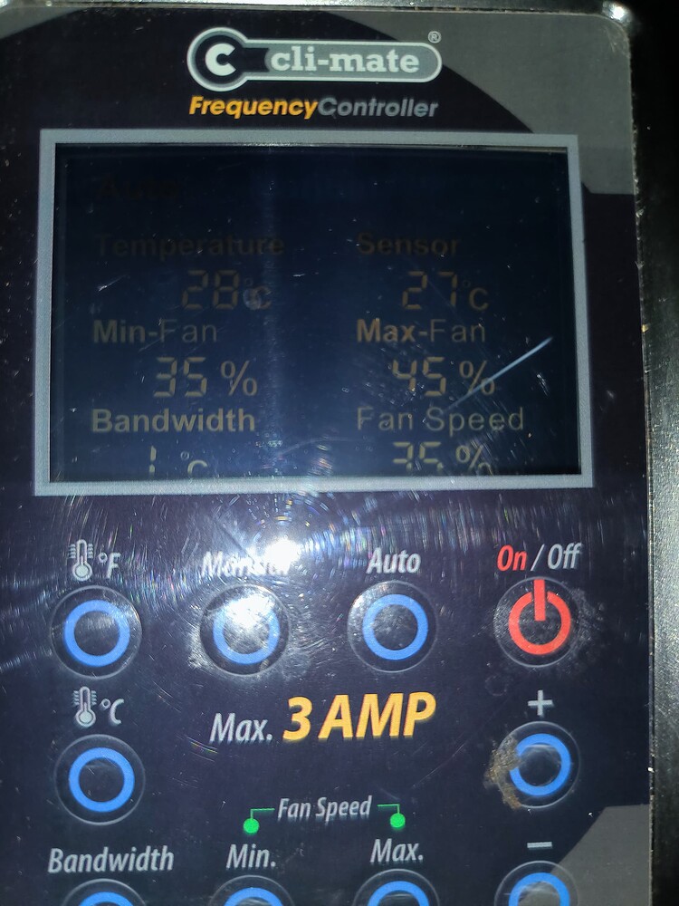 Ein Klimasteuerungsgerät mit einem digitalen Display, das Temperatur- und Lüftereinstellungen anzeigt, sowie Bedienelementen darunter.